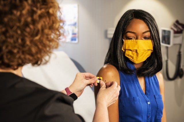 Bandage after vaccination, representing public health efforts